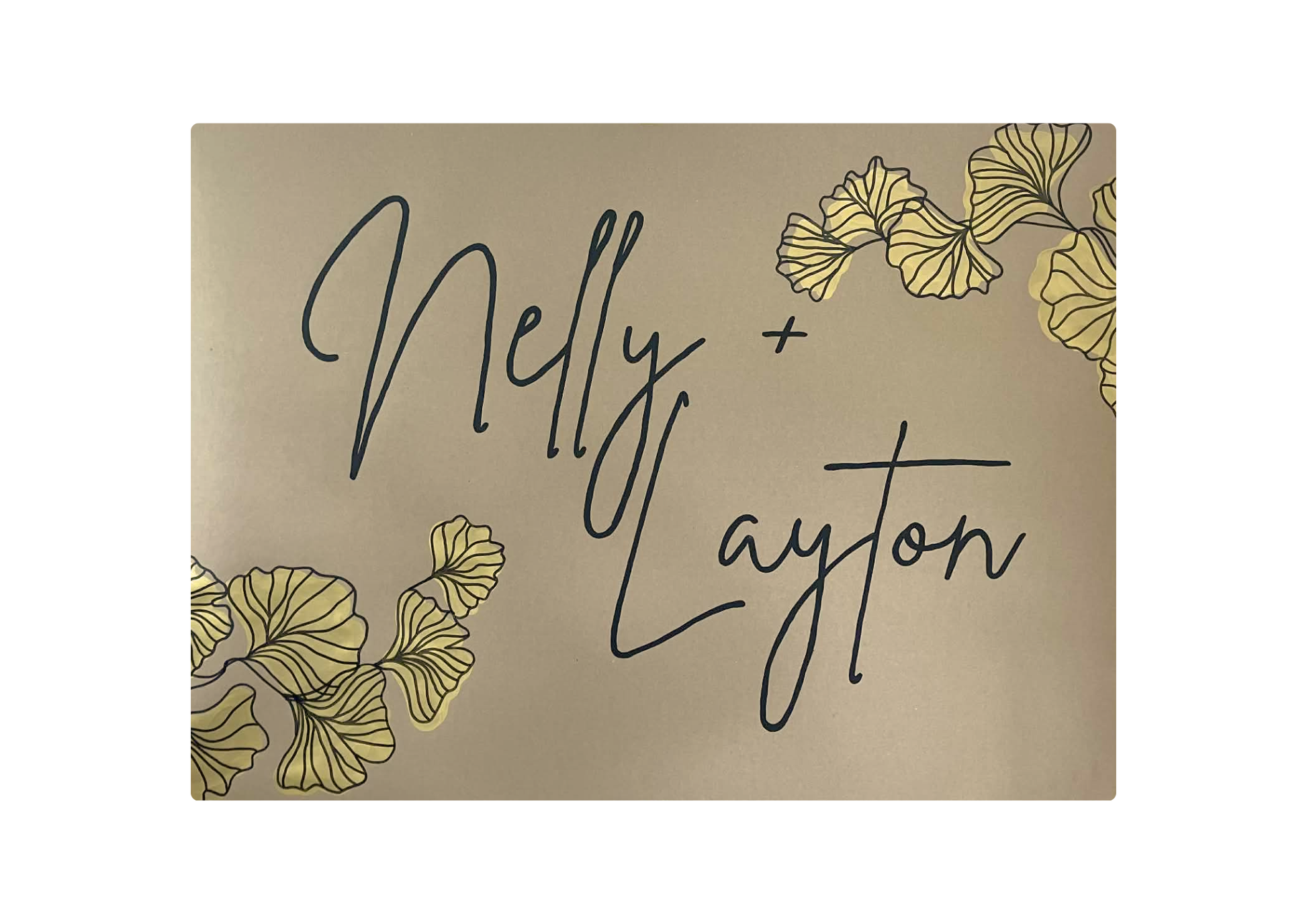 Card with 'Nelly + Layton' text and gold leaf designs on a beige background